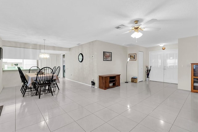 tiled dining area with ceiling fan with notable chandelier