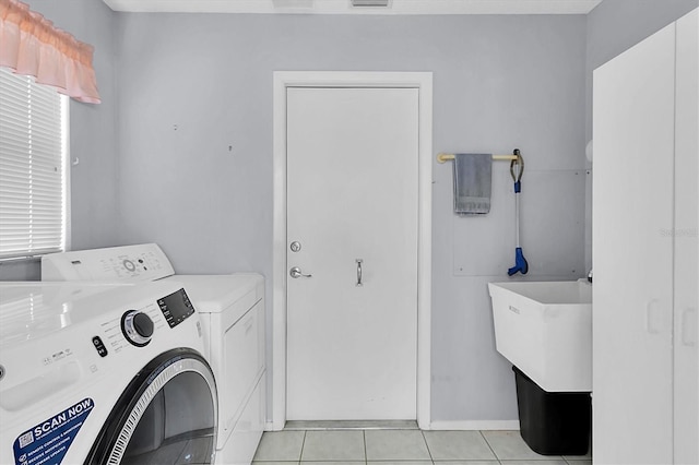 washroom featuring washer and clothes dryer and light tile patterned flooring