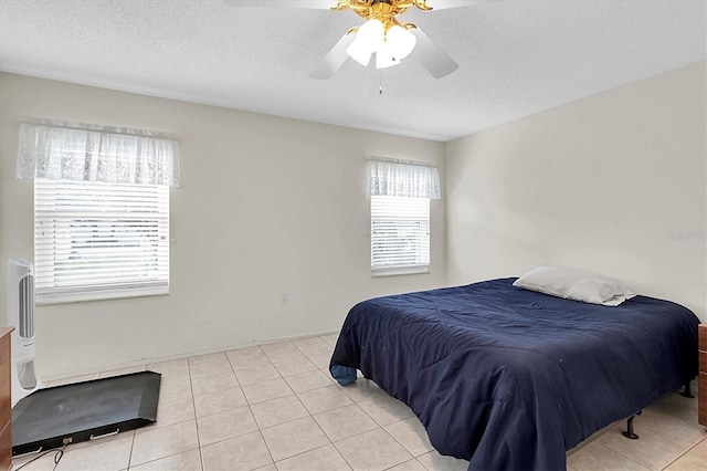 bedroom featuring a textured ceiling, ceiling fan, and light tile patterned floors