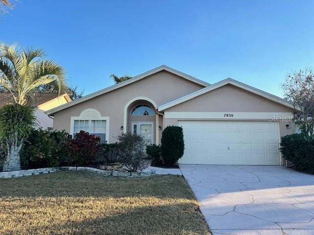 single story home featuring a garage and a front lawn