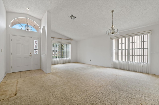 entrance foyer with light carpet, visible vents, an inviting chandelier, a textured ceiling, and high vaulted ceiling