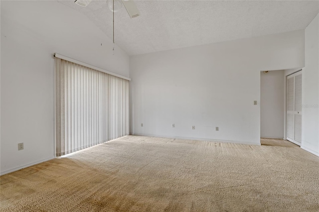 unfurnished room featuring a textured ceiling, high vaulted ceiling, and light colored carpet