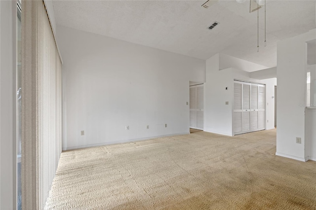 unfurnished room with visible vents, light carpet, and baseboards