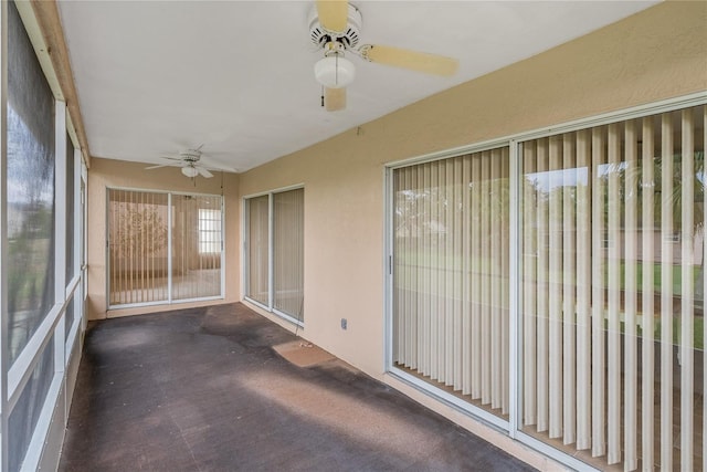 unfurnished sunroom featuring a ceiling fan