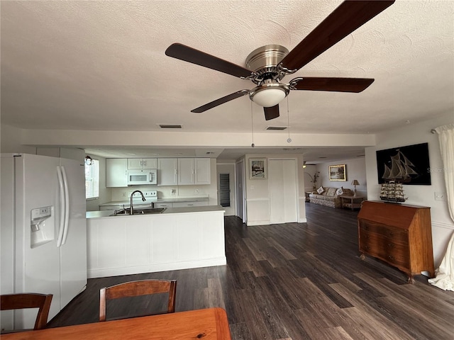 kitchen with kitchen peninsula, dark hardwood / wood-style flooring, white appliances, ceiling fan, and sink