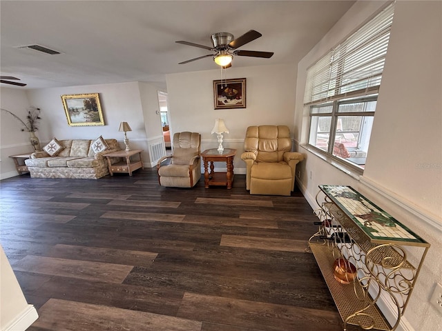 living area featuring ceiling fan and dark wood-type flooring