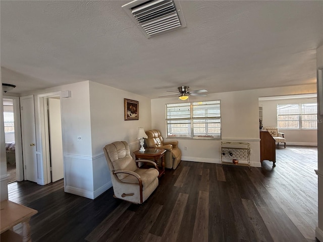 sitting room with a textured ceiling, dark hardwood / wood-style flooring, and ceiling fan