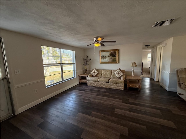 unfurnished living room featuring ceiling fan, dark hardwood / wood-style flooring, and a textured ceiling