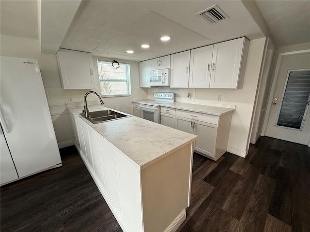 kitchen featuring white appliances, white cabinetry, dark wood-type flooring, and sink