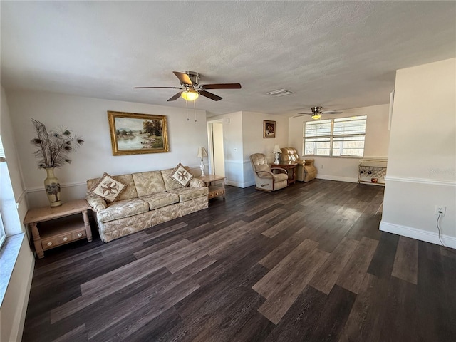 unfurnished living room featuring dark hardwood / wood-style flooring, ceiling fan, and a textured ceiling