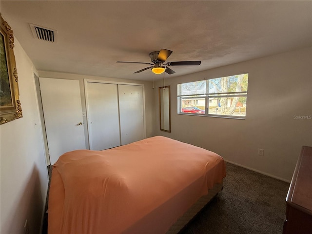 bedroom featuring dark carpet, ceiling fan, and a closet