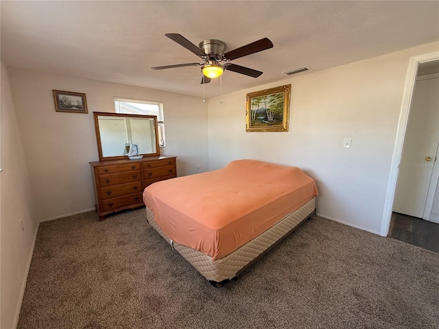 carpeted bedroom featuring ceiling fan and a textured ceiling