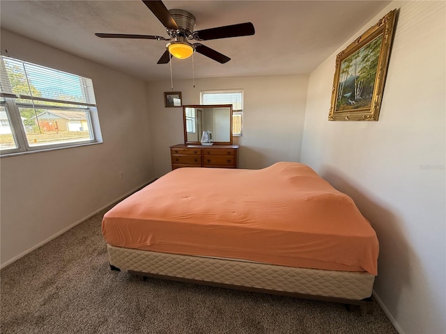 carpeted bedroom featuring ceiling fan and multiple windows