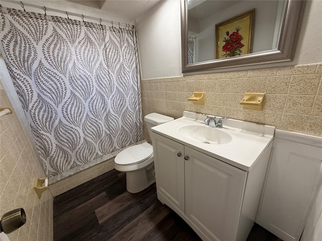 bathroom featuring toilet, a shower with curtain, tile walls, hardwood / wood-style floors, and vanity