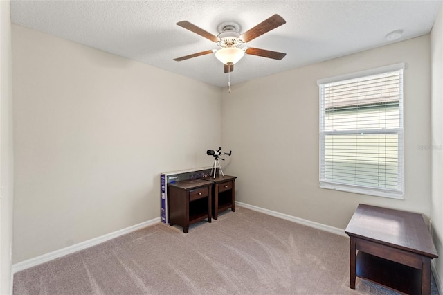 miscellaneous room featuring a textured ceiling, ceiling fan, and light carpet