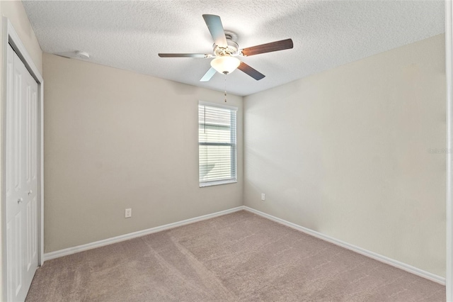 unfurnished bedroom with ceiling fan, light colored carpet, a textured ceiling, and a closet