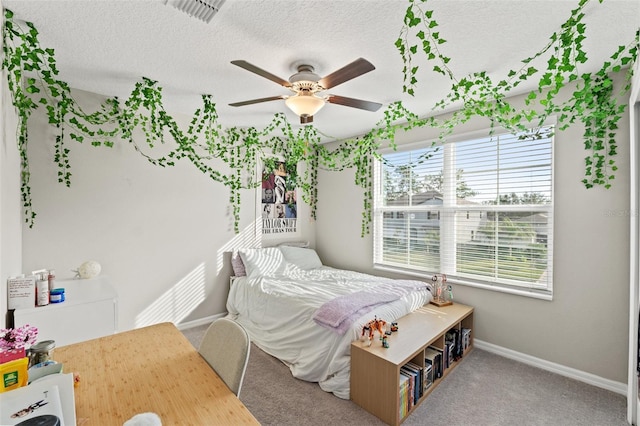 bedroom featuring carpet flooring, ceiling fan, and a textured ceiling