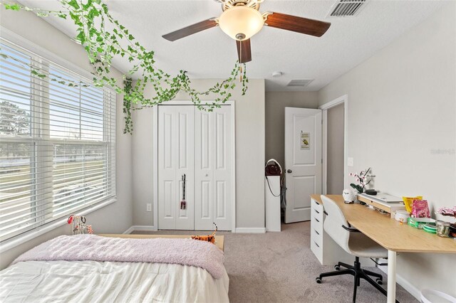 carpeted bedroom featuring ceiling fan and a closet