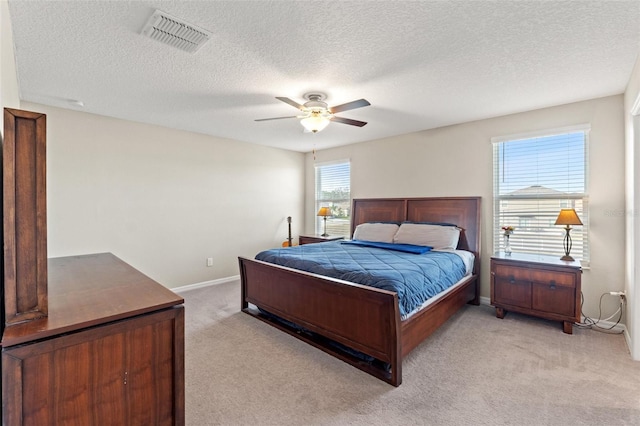 carpeted bedroom with ceiling fan and a textured ceiling