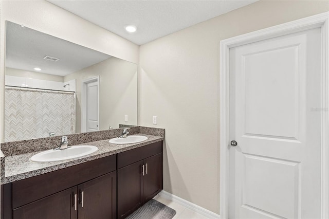 bathroom with tile patterned flooring, vanity, curtained shower, and a textured ceiling