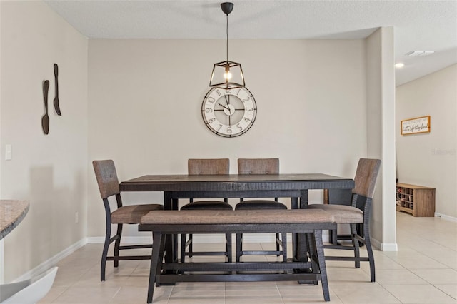 tiled dining space featuring a textured ceiling