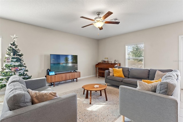 living room with a textured ceiling and ceiling fan