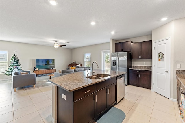 kitchen with a kitchen island with sink, sink, ceiling fan, appliances with stainless steel finishes, and dark brown cabinetry