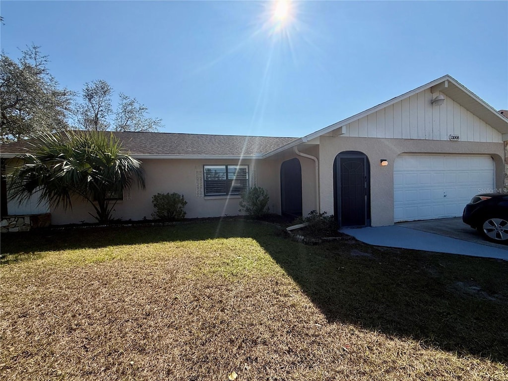 ranch-style house featuring a garage and a front lawn