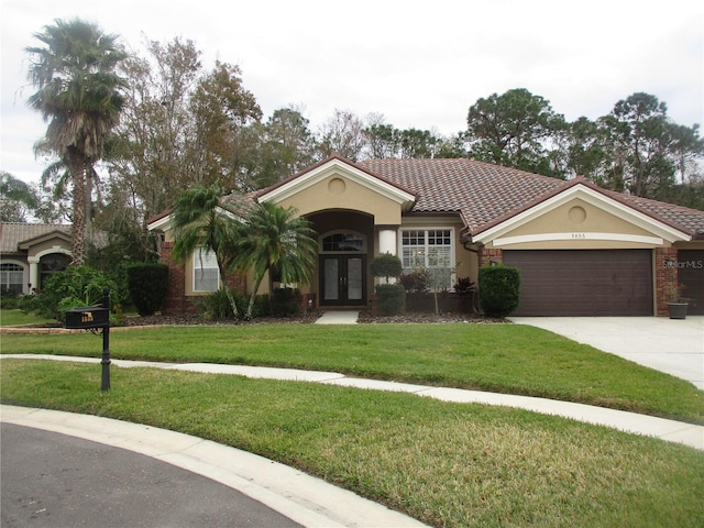 view of front of home with a garage, a front yard, and french doors