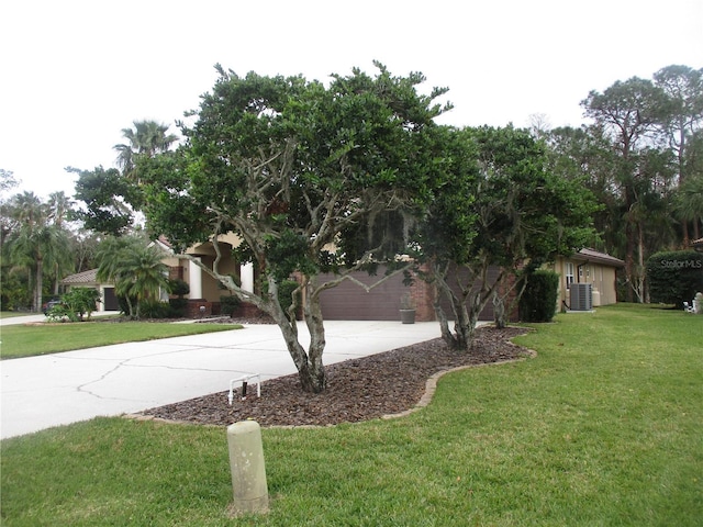 exterior space with a front lawn, central AC unit, and a garage