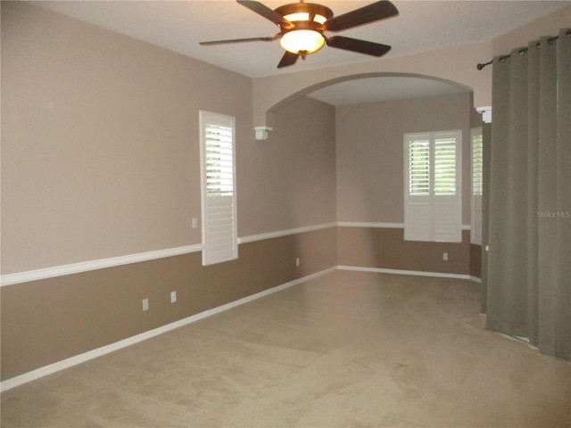 unfurnished room featuring light colored carpet, ceiling fan, and a healthy amount of sunlight