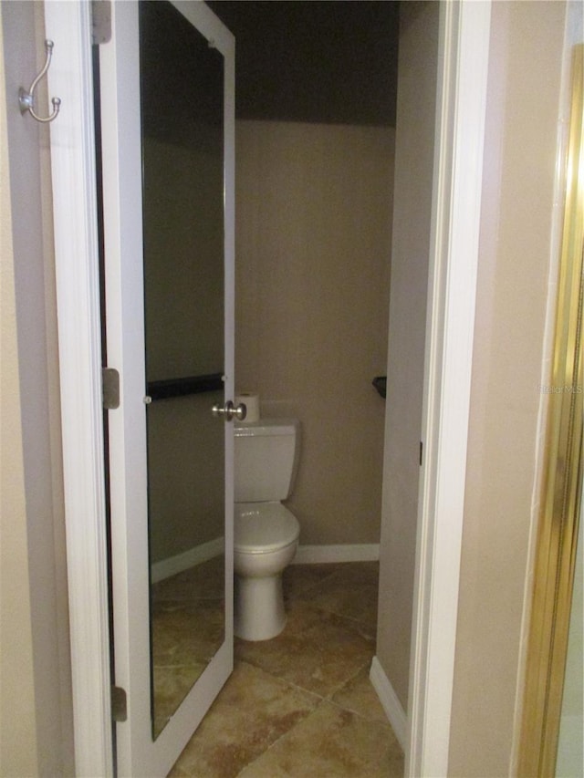 bathroom featuring a shower, tile patterned floors, and toilet