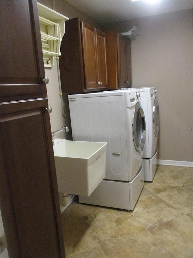 washroom with cabinets, separate washer and dryer, and sink