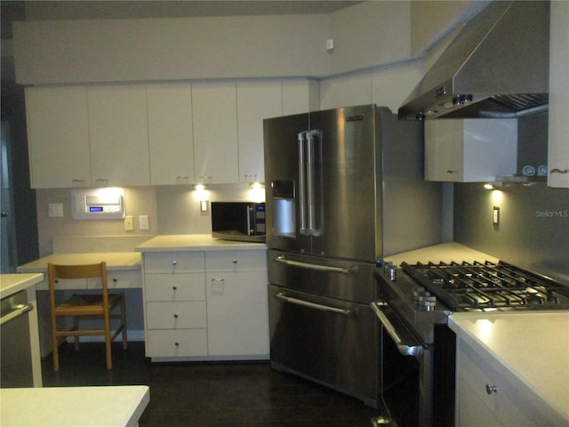 kitchen featuring white cabinets, range hood, and appliances with stainless steel finishes