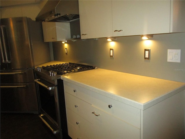 kitchen featuring white cabinetry, ventilation hood, and appliances with stainless steel finishes