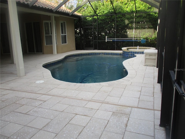 view of pool featuring an in ground hot tub, a patio, and a lanai