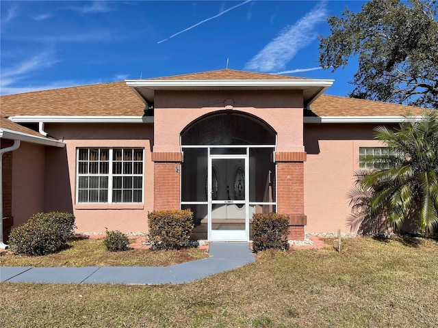 doorway to property with a lawn