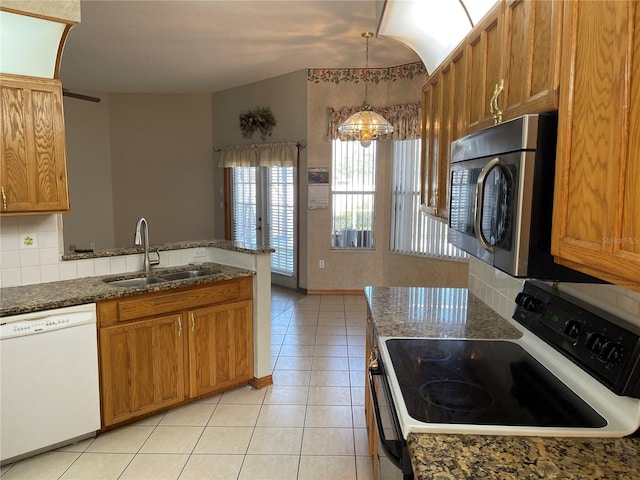 kitchen featuring pendant lighting, dishwasher, backsplash, sink, and electric range