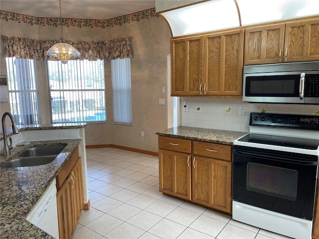 kitchen featuring white appliances, sink, decorative light fixtures, light tile patterned floors, and a notable chandelier