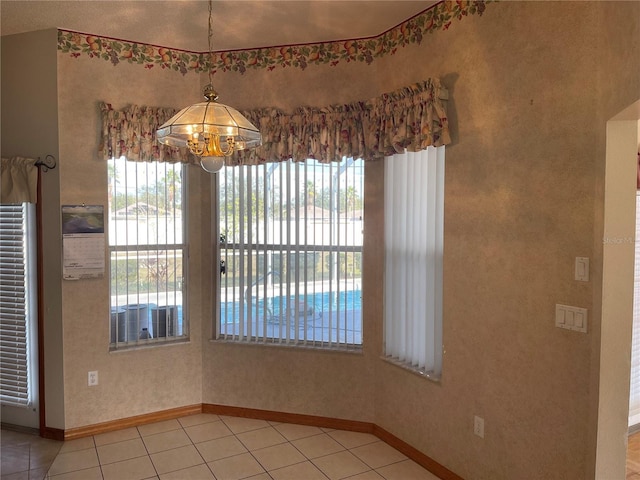 unfurnished dining area with tile patterned flooring and a chandelier