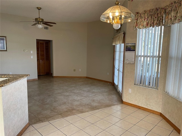 unfurnished dining area featuring ceiling fan and light tile patterned floors