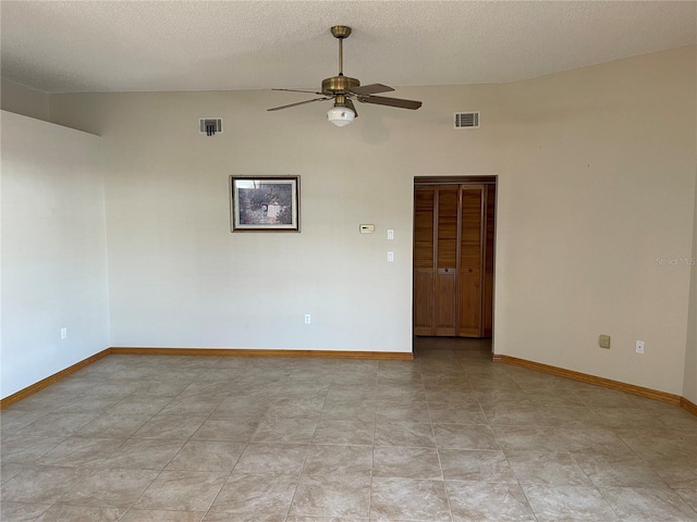 empty room featuring a textured ceiling, ceiling fan, and lofted ceiling