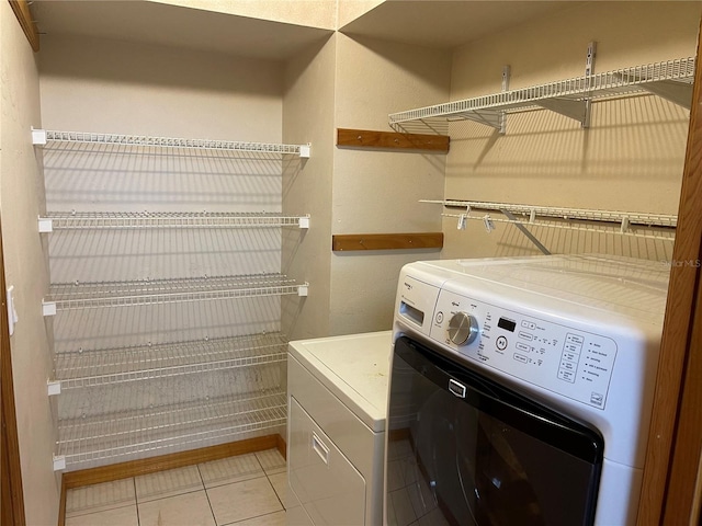 washroom with independent washer and dryer and light tile patterned flooring