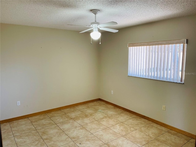 empty room with a textured ceiling, ceiling fan, and light tile patterned flooring