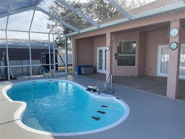 view of pool with french doors, a patio, and glass enclosure