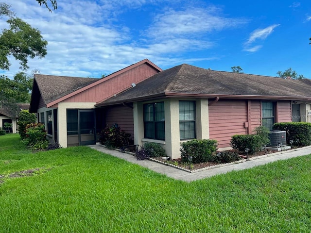 view of side of home with central air condition unit and a lawn