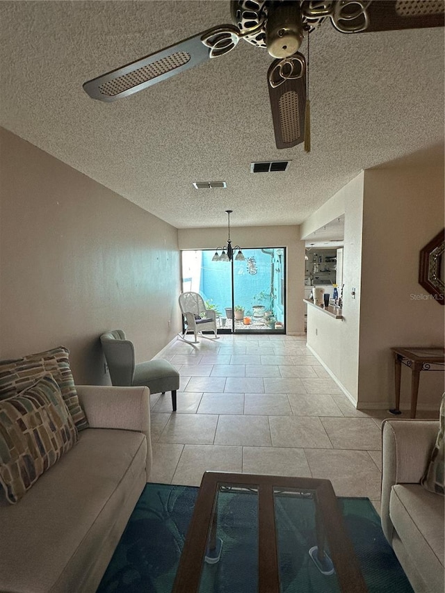 unfurnished living room featuring ceiling fan, light tile patterned flooring, and a textured ceiling