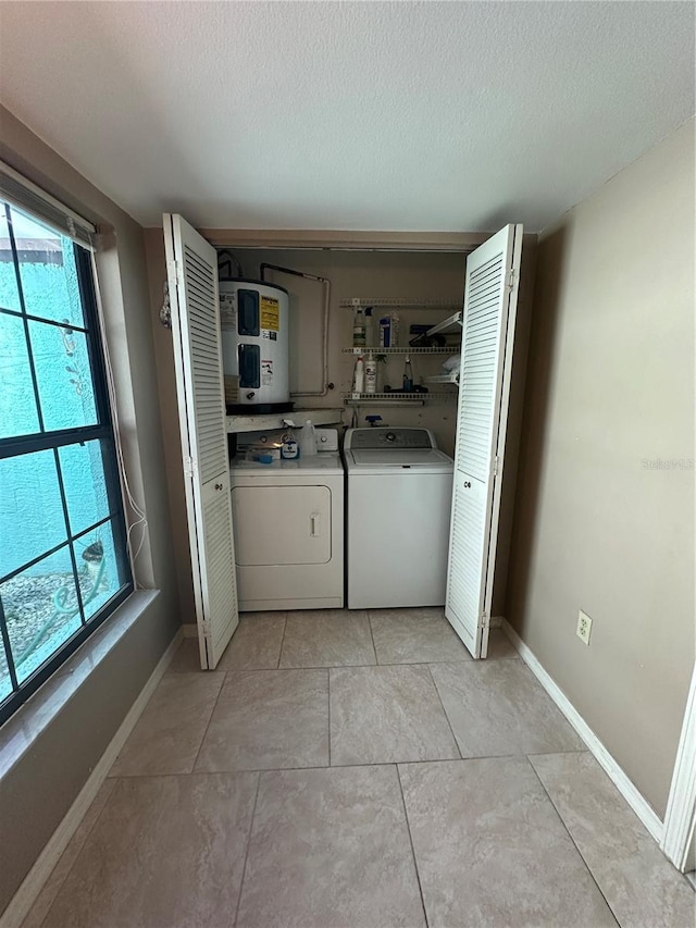 washroom featuring independent washer and dryer, a textured ceiling, a wealth of natural light, and light tile patterned flooring