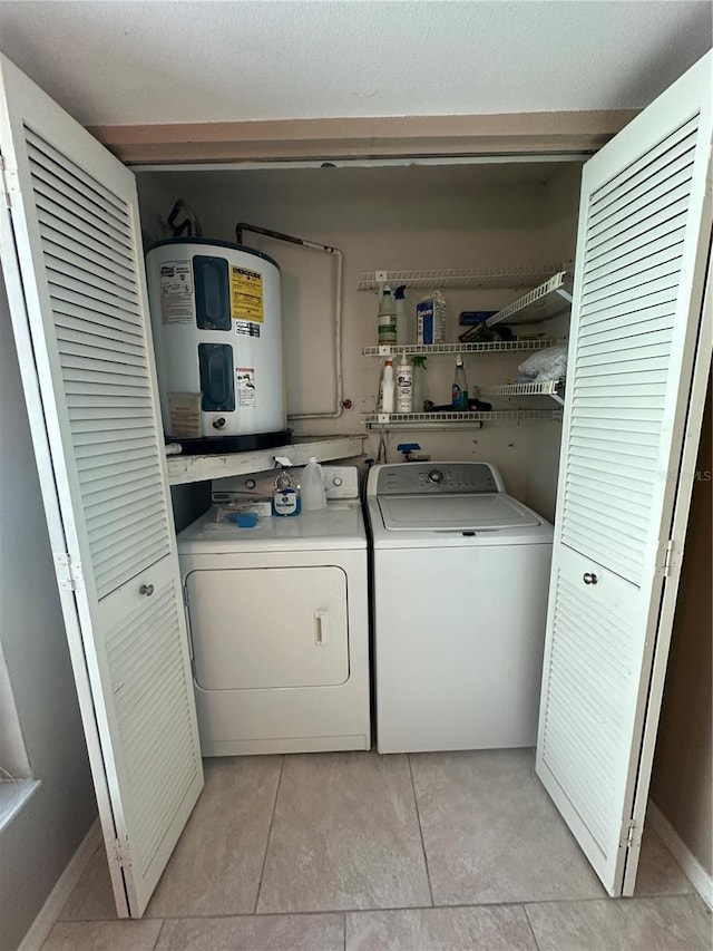 laundry area with washer and clothes dryer, light tile patterned floors, and water heater