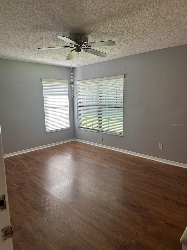 empty room featuring a textured ceiling, ceiling fan, and dark wood-type flooring